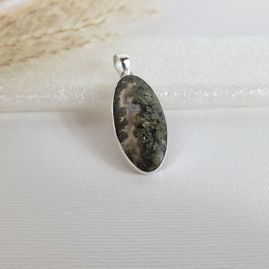 Moosachat Kettenanhänger mit grünen, moosartigen Einschlüssen in 925er Silberfassung, 3,2 x 1,6 cm, auf neutralem Hintergrund.