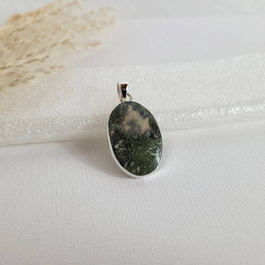 Moosachat Kettenanhänger mit grünen, moosartigen Einschlüssen in 925er Silberfassung, 2,6 x 1,8 cm, auf neutralem Hintergrund.
