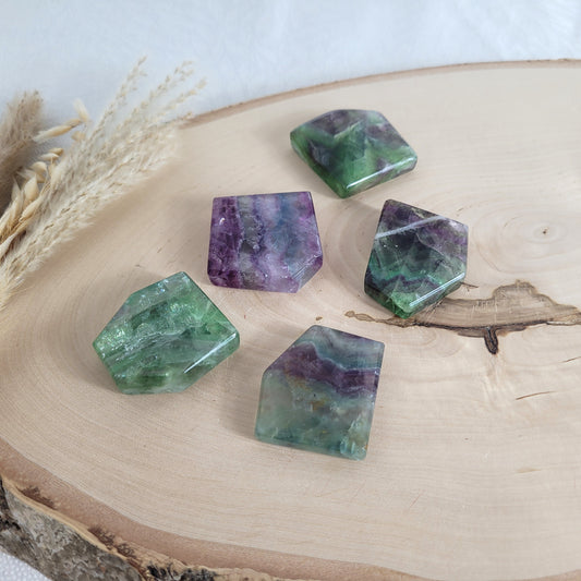 Bunte Fluorit Kristallscheibe mit Bänderung und leuchtender Struktur, präsentiert auf einer runden naturbelassenen Holzscheibe jede Scheibe ein Unikat
