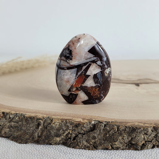 Diese Brekzien Jaspis Freiform zeigt intensive Naturfarben und wilde Muster. Durchzogen von Chalcedon-Adern, die teils kristallin und teils opalisierend sind, entsteht eine faszinierende Tiefe.